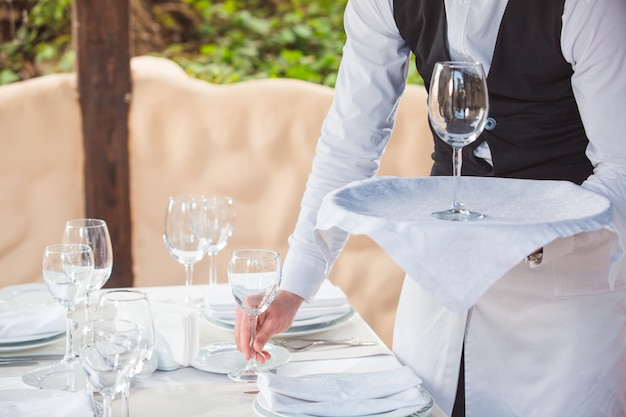 The waiter works in a restaurant on the summer terrace