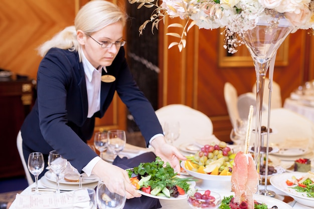 Waiters set the tables in the restaurant for the banquet