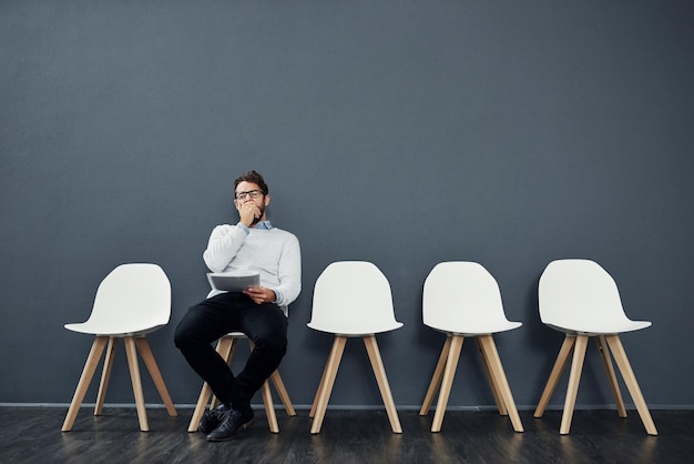 Photo waiting room tired and businessman for recruitment hiring and job interview in office chair yawn and male person as candidate of human resources exhausted and fatigue with paper in workplace