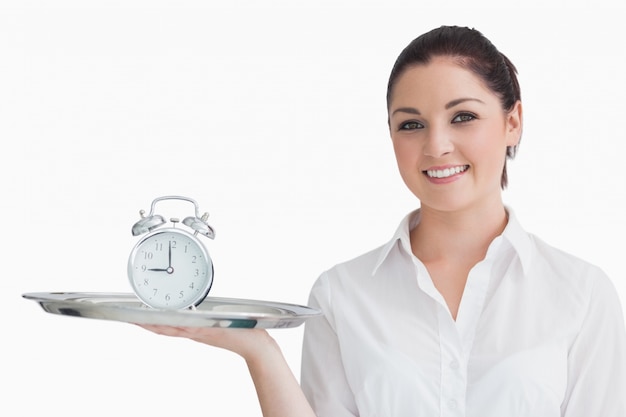 Waitress holding alarm clock on a tray