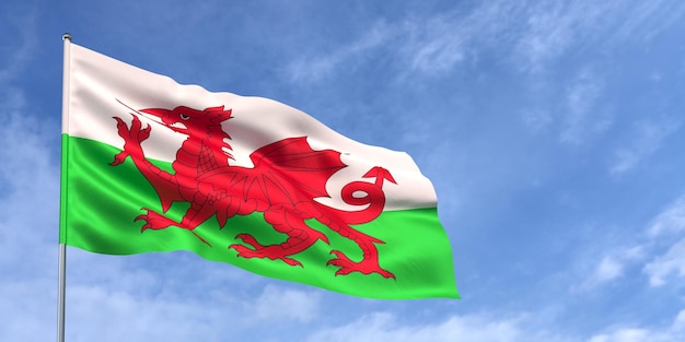 Wales flag on flagpole on blue sky background Welsh flag waving in wind against a sky with white clouds Place for text 3d illustration