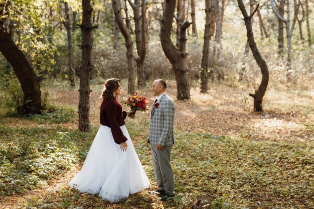 Walk of the bride and groom through the autumn forest in October