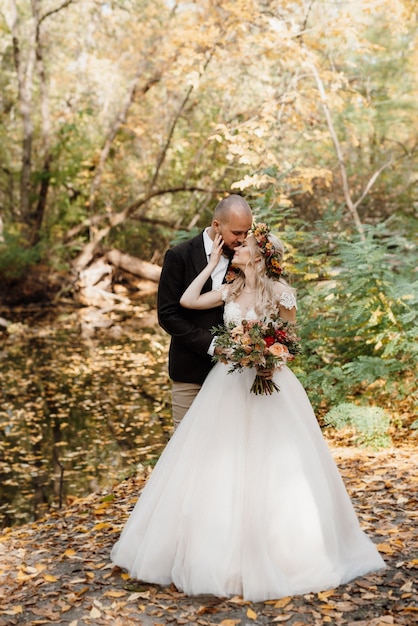 Walk of the bride and groom through the autumn forest