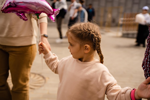 A walk in the park with her parents a girl holding her parents39 hands holding a balloon in her han