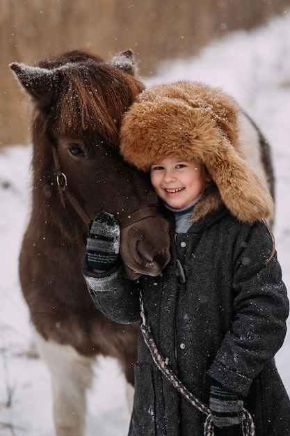 Walk on snow paths in winter among the reeds of the pony and the baby