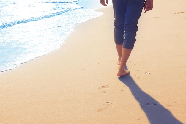 Walking on the beach leaving footprints in the sand