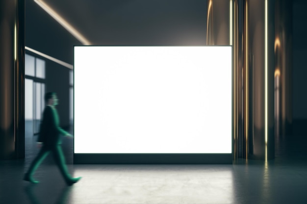 Walking businessman by blank white illuminated big screen with place for your logo or text between golden pillars with glossy floor on dark empty room background mock up