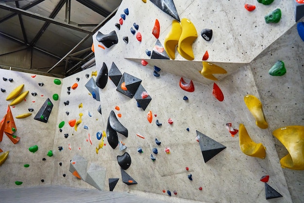 Wall for bouldering in gym with holds for climbing active extreme sport concept