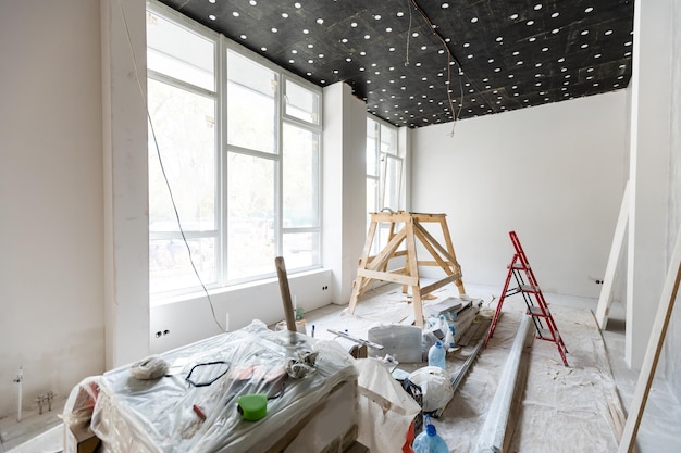 The wall of the building is covered with fresh plaster and surrounded by construction. Background.