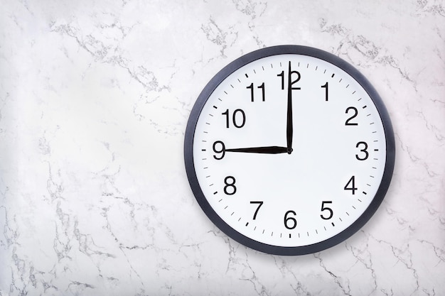 Wall clock show nine o'clock on white marble texture Office clock show 9pm or 9am