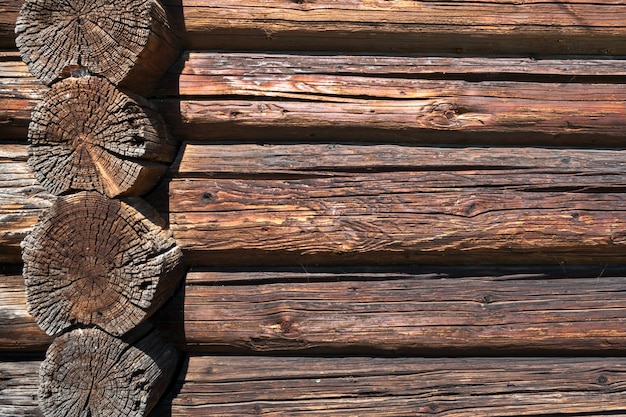 Wall from old dilapidated longitudinal and transverse logs.