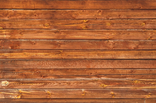 The wall of the house is made of old brown timber.