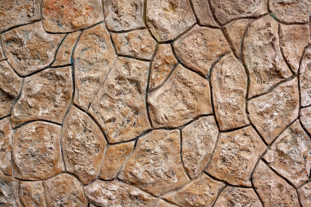 Wall is built of stones well fitted to each other. Stone background. Horizontal photo.