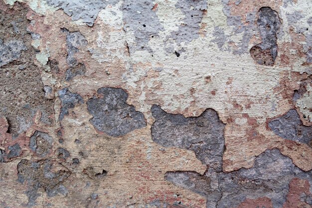 The wall is covered with many layers of paint and rust,