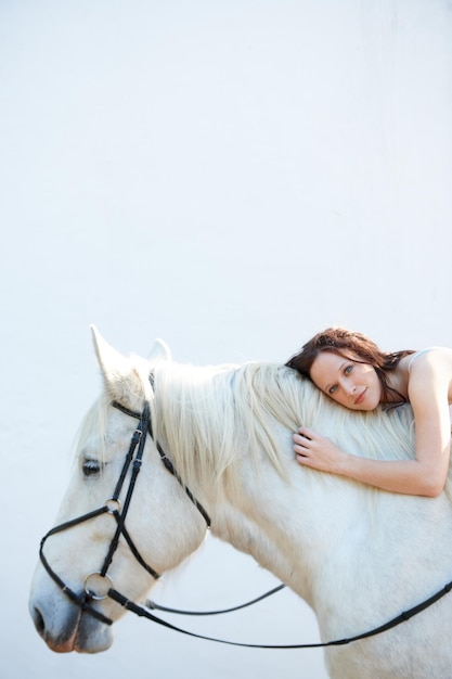 Wall portrait and woman laying on her horse outdoor for sports racing or riding hobby Smile happy and young person from Canada with her equestrian animal or pet by a ranch for adventure and love