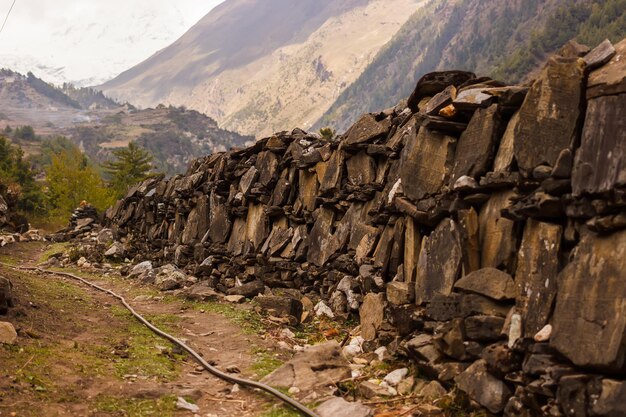 Wall of prayer stones along the trail in the Himalayas in the Manaslu region