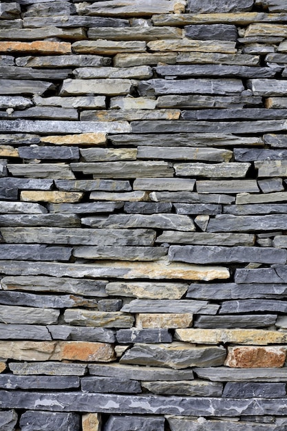 A wall of slates with a white base and a red bucket on top of it.