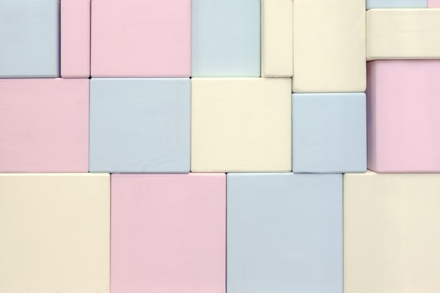 The wall of wooden rectangular shapes of different sizes of blue yellow and pink