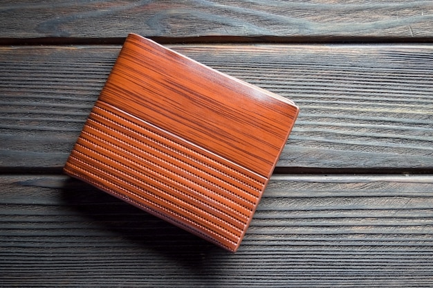 Wallet male brown on a wooden background