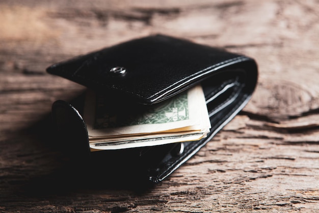 Wallet with dollar bills on the table