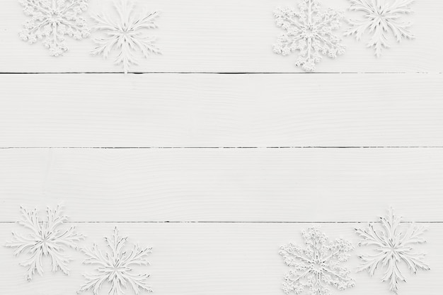 Wallpaper with white snowflakes on white wooden background.