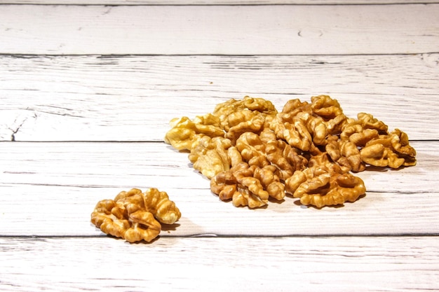 Walnut kernels in the white bowl on wooden background Tasty and healthy dried walnut kernels