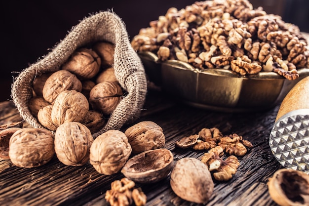 Walnut kernels whole walnuts in burlap sack and vintage bowl.