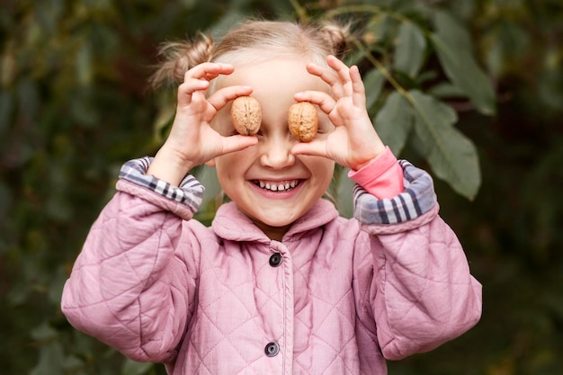 Walnuts in Child in front of Eyes on Nature Background. Nuts for Children. Eco Food for Children.