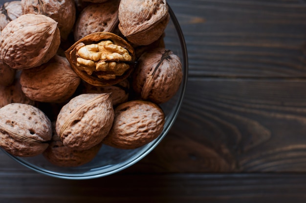 Walnuts in a glass bowl on wooden table