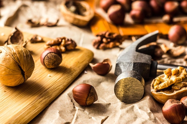 Walnuts and hazelnuts are on the table. Whole and broken nutshells lie on a brown background