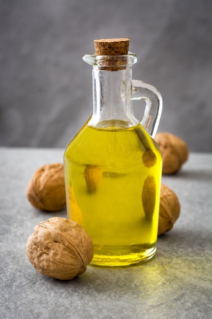 Walnuts oil in jar on gray