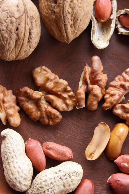 Walnuts and peanuts on a clay plate Vegan food Peeled and unshelled nuts on a brown clay bowl closeup