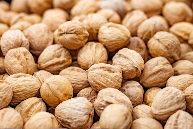 Walnuts unpeeled whole in bulk on market selective focus