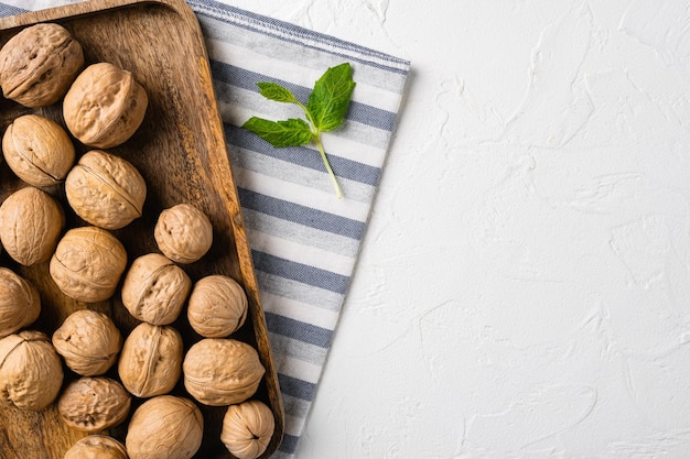 Walnuts with shells set on white stone table background top view flat lay with copy space for text