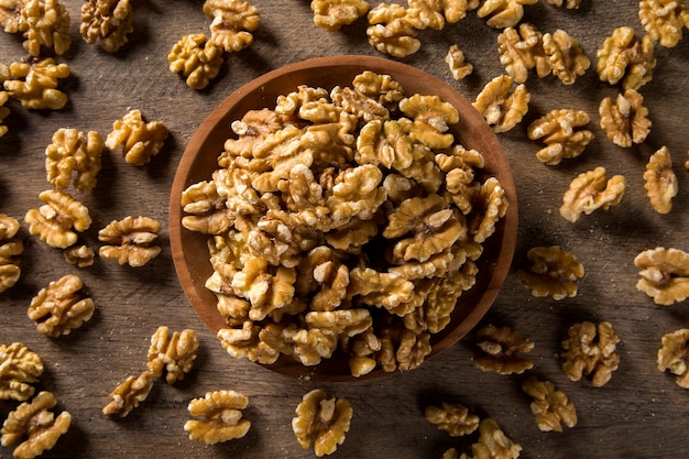 walnuts in wood bowl on wood table.