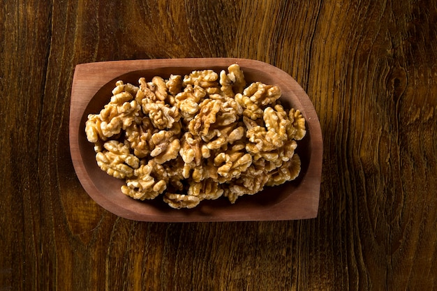 walnuts in wood bowl on wood table.