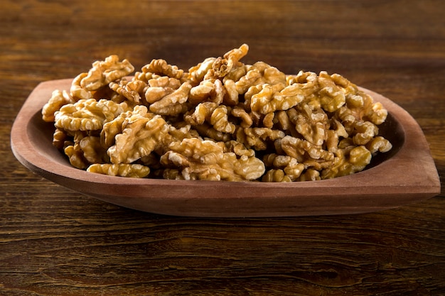 walnuts in wood bowl on wood table.