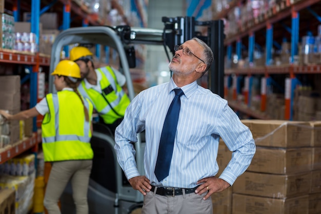 Warehouse manager standing with hands on hips