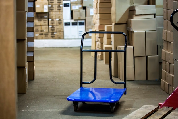 Warehouse with goods in boxes and trolleys for transportation of goods close-up.