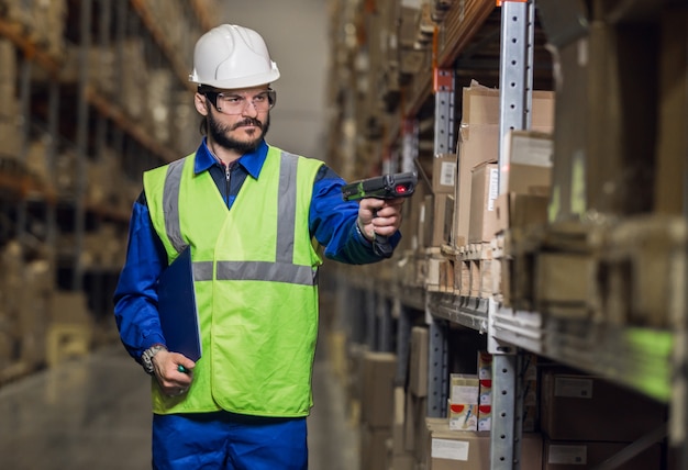 Warehouse worker checking cargo on shelves with scanner