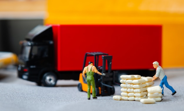 Warehouse workers forklift carrying sacks to semi truck with trailer