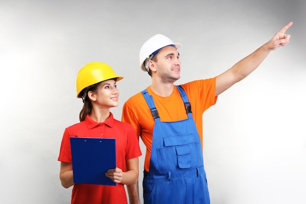 Warehouse workers with clipboard discussing something on light background