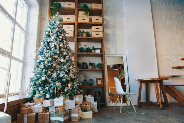 Warm cozy beautiful modern design of the room in delicate light colors decorated with christmas tree