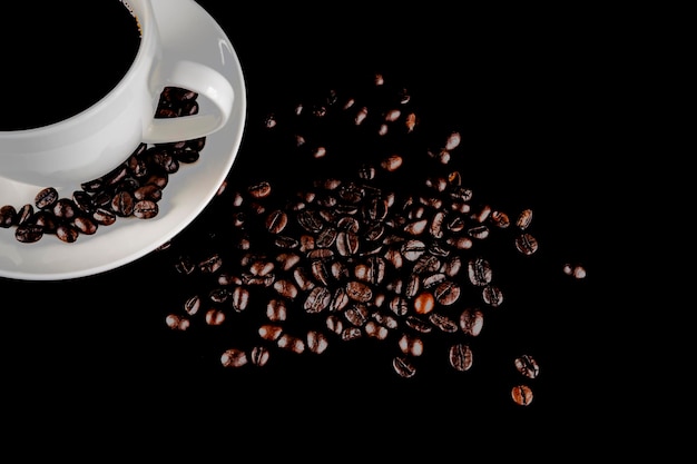 Warm cup of coffee with coffee beans over black background