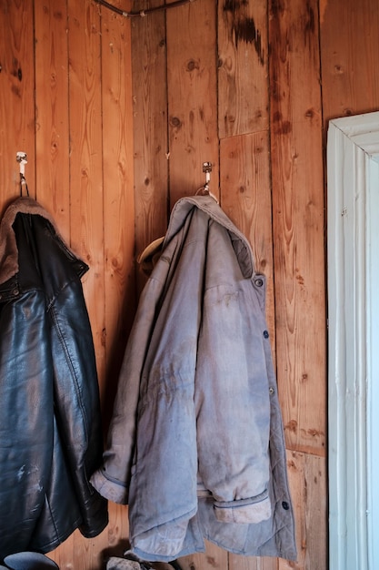 Warm jackets for work in the garden hang on a wooden wall in a country house