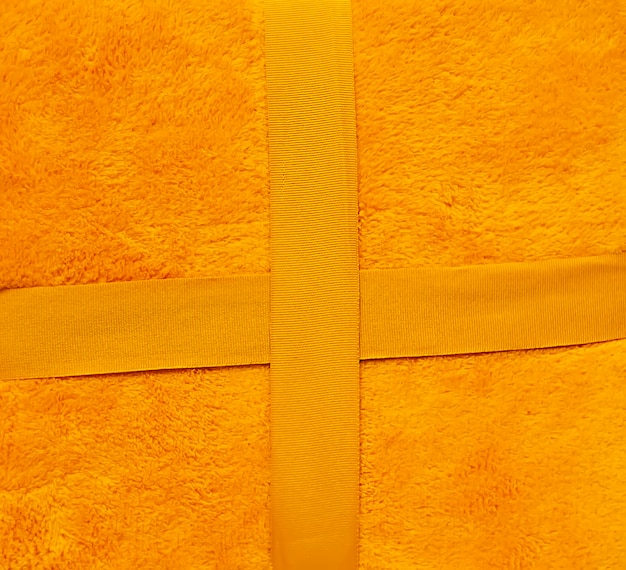 Warm soft yellow plaid surface close up. Synthetic cloth texture.