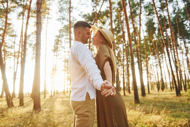 Warm weather Happy couple is outdoors in the forest at daytime