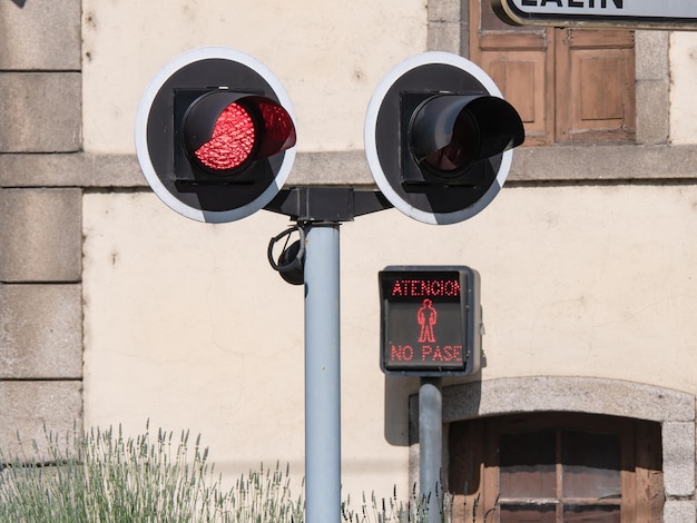 Warning lights for pedestrians and drivers lit at a level crossing due to the proximity of a train