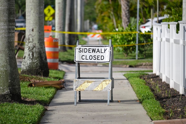 Warning sign that sidewalk is closed at street construction site Utility work ahead