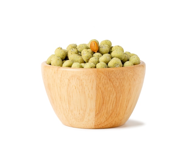 Wasabi crispy peanut snack balls in a wooden cup isolated on white space.